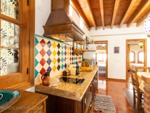 a kitchen with a stove and a counter top at Casa maria la conejera in Nigüelas +18 photos