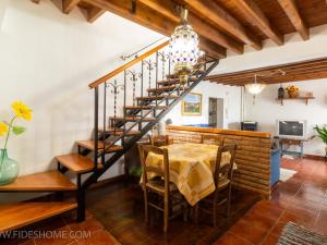 une salle à manger avec une table et un escalier en colimaçon dans l'établissement Casa maria la conejera, à Nigüelas