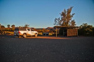 a white truck parked next to a bus stop at Palmwag Campsite in Palm