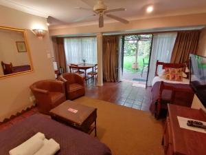 Dias Guest House في بلومفونتين: غرفة معيشة مع أريكة وسرير