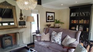 a living room with a couch and a fireplace at Avianto in Muldersdrift