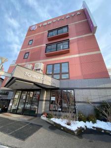 un edificio rojo alto con un letrero. en Towada City Hotel, en Towada