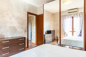 een slaapkamer met een spiegel, een bed en een dressoir bij Relax Apartment in Ladispoli