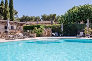 una piscina con sillas y sombrillas frente a una casa en Mas de Fauchon - Teritoria, en Saint-Cannat