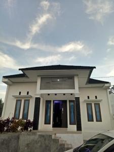a small white house with a large door at Villa SINGGALANG Syariah in Padangluar +21 photos