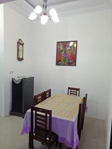 a dining room with a table with a purple table cloth at Villa SINGGALANG Syariah in Padangluar