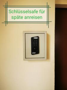 eine Fernbedienung in einem Bilderrahmen an einer Wand in der Unterkunft Pension Bremer in Lindenthal