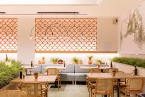 a restaurant with tables and chairs and a large window at Ars Magna Bleisure Hotel in Palma de Mallorca