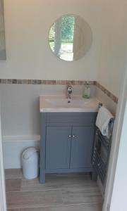a bathroom with a sink and a mirror at Yew Tree View in Marnhull