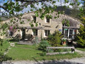a stone house with a bench in front of it at Malia - Chambres d'hôtes & Gîte in Barret-de-Lioure