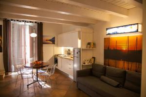 a living room with a couch and a table and a kitchen at Naturalliving in Catania