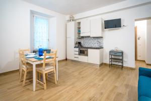 a kitchen and dining room with a table and chairs at Valle dei Mulini - Appartamenti in Bellano