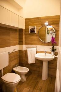 a bathroom with a sink and a toilet and a mirror at Naturalliving in Catania