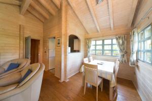 a small room with a table and chairs and a kitchen at Cherry Log Cabin in Swanage