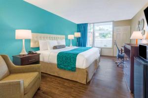 a large hotel room with a bed and a couch at Howard Johnson by Wyndham Lakeland in Lakeland