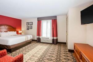 a hotel room with a bed and a flat screen tv at La Quinta by Wyndham North Platte in North Platte