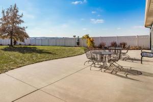 a patio with tables and chairs in a yard at La Quinta by Wyndham North Platte in North Platte