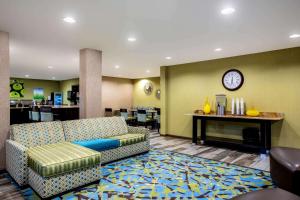 a waiting room with a couch and a clock on the wall at La Quinta by Wyndham Emporia in Emporia