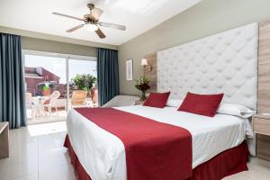a bedroom with a large white bed with red pillows at Los Arcos in Nerja