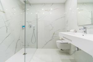 a white bathroom with a shower and a sink at Los Arcos in Nerja