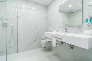a white bathroom with a sink and a toilet at Los Arcos in Nerja