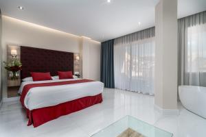 a bedroom with a large bed and a bath tub at Los Arcos in Nerja