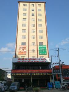 wysoki budynek z znakiem przed nim w obiekcie PACI Hotel&SPA w mieście Preăh Sihanŭk