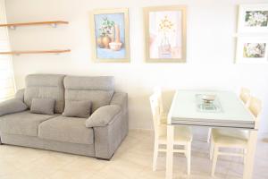ein Wohnzimmer mit einem Sofa und einem Tisch in der Unterkunft Sol Daurat seafront apartment in Cambrils