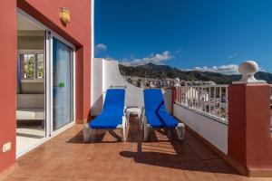 two blue chairs on a balcony with a view at Los Arcos in Nerja