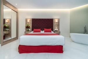 a bedroom with a large bed and a bath tub at Los Arcos in Nerja