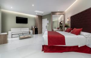 a bedroom with a large bed and a living room at Los Arcos in Nerja