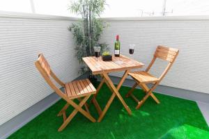 a table with two chairs and a bottle of wine at CuteFamilyHouse! 3LDK 6minShinjuku 3minJRsta Cozy,Fun,Bright! KidsFree Under6yrs in Tokyo