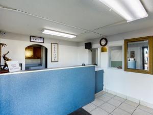 a waiting room with a blue counter and a clock at OYO Hotel Pensacola I-10 & Hwy 29 in Pensacola