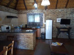 a kitchen with a white refrigerator and a table at Jacaranda Self Catering Chalets in Krugersdorp