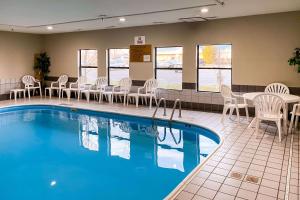 a pool with chairs and tables in a hotel room at Quality Inn Michigan City South in Michigan City