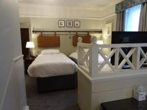 a small bedroom with a bed and a window at The Belmore in Sale