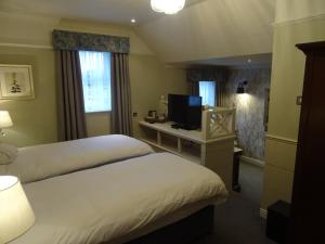 a hotel room with two beds and a television at The Belmore in Sale