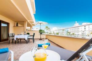 a balcony with a table and two glasses of orange juice at Drac Blanc 1-3 in Cala Ratjada