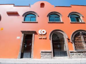 an orange building with windows and a sign for a sun cafe at Capital O San Jose, San Luis Potosi in San Luis Potosí