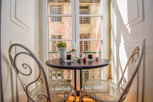 un tavolo e sedie di fronte a una finestra di B in B Lisbon Downtown Suites a Lisbona