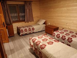 Habitación con 2 camas en una cabaña de madera en Willa Wiktoria, en Zawoja