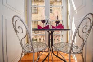 uma mesa com duas cadeiras em frente a uma janela em B in B Lisbon Downtown Suites em Lisboa