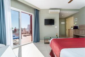 a hotel room with a bed and a sliding glass door at Los Arcos in Nerja