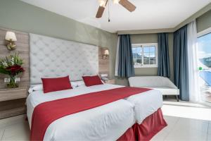 a bedroom with a large bed with red pillows at Los Arcos in Nerja