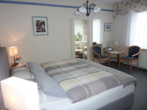 1 dormitorio con 1 cama, mesa y sillas en Pension Rheingold Garni, en Bad Grund