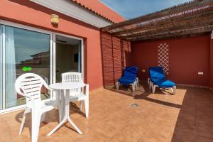 a patio with two chairs and a table and chairs at Los Arcos in Nerja