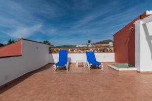 two blue chairs on the roof of a house at Los Arcos in Nerja