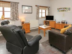 a living room with two chairs and a television at Jack's Nest in Rose Ash