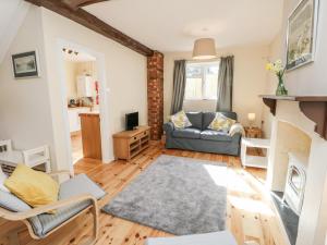 a living room with a couch and a fireplace at Bugle Cottage in Newport