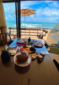 einen Tisch mit Essen drauf mit Blick auf den Strand in der Unterkunft SuRFCoRe House in Baía Formosa